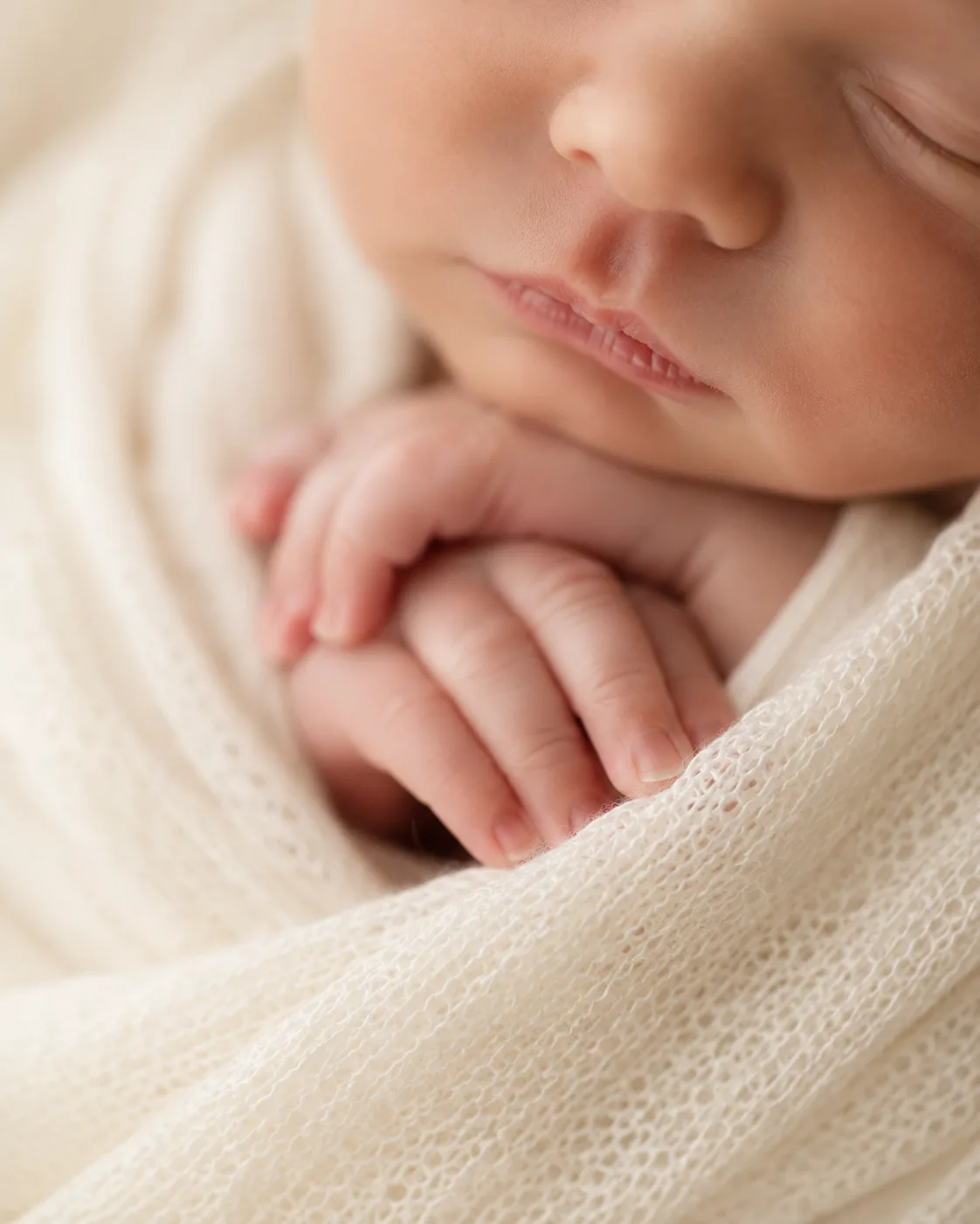Close-up detail of a sleeping newborn&rsquo;s hand and face, Tampa newborn photography style sample